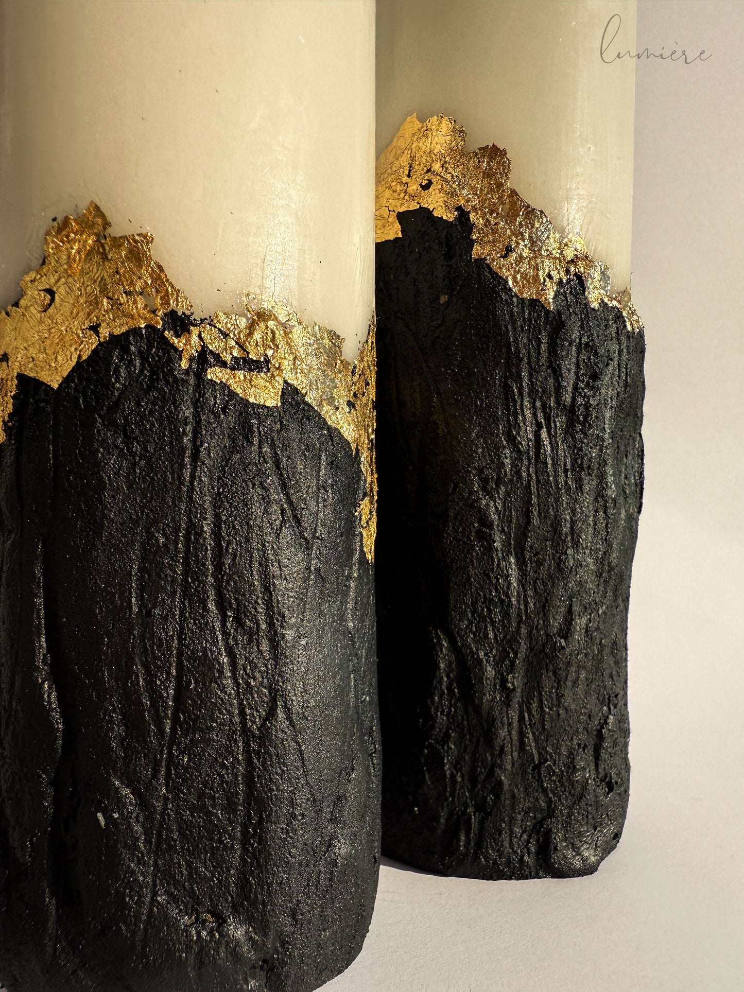 Close-up of rough surface and embedded golden accents in minimalist candle set