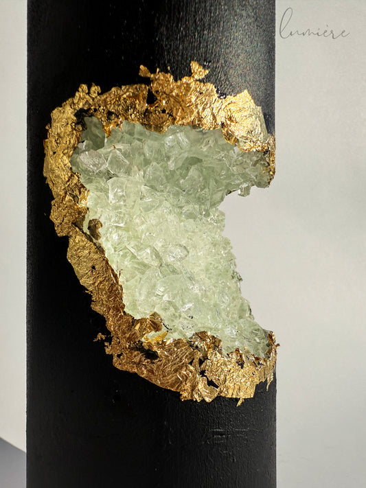 Close-up of handmade golden crystals embedded in sculpted black concrete