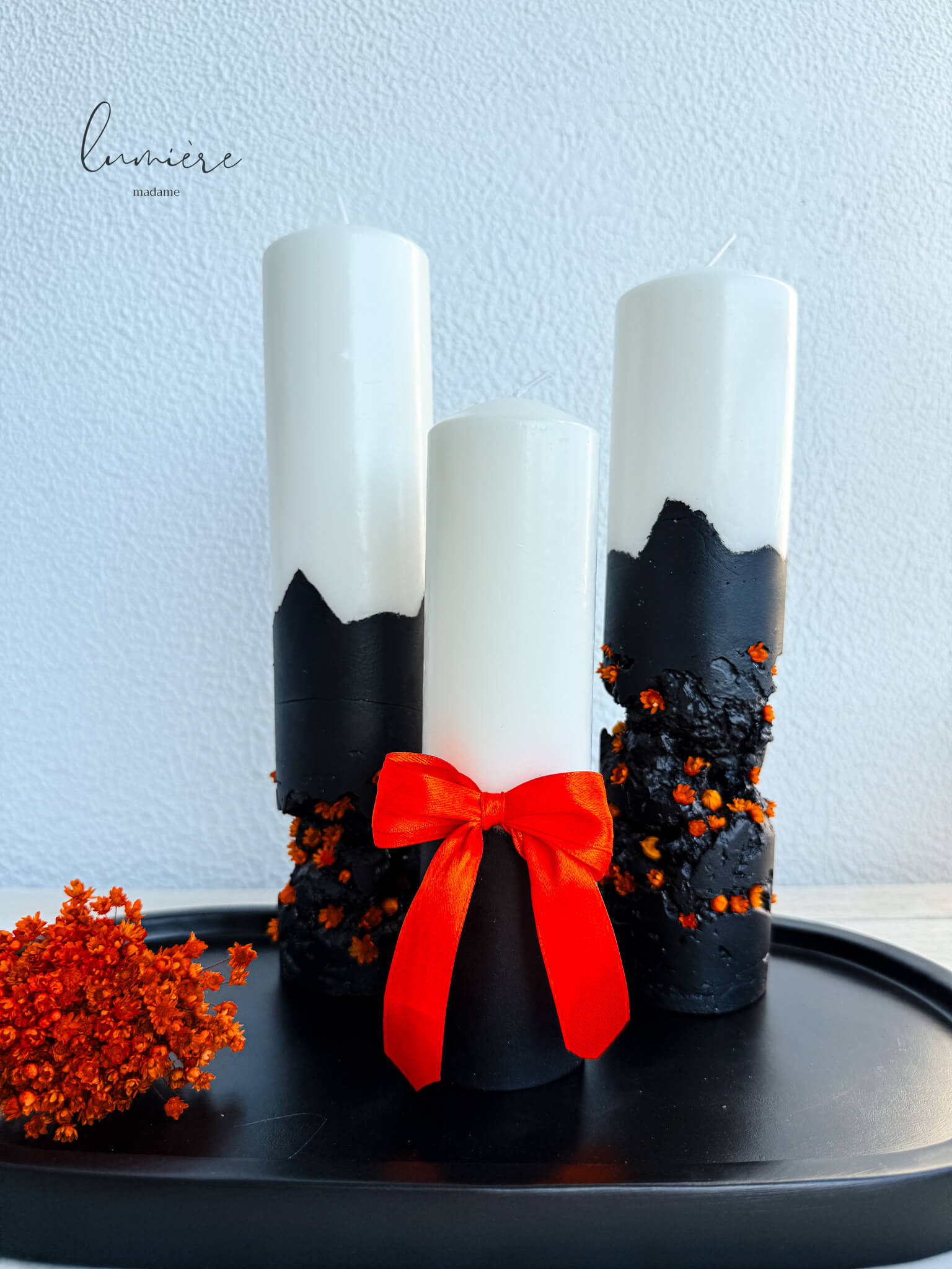 Lumânare Black Ember cu fundiță portocalie decorativă și textură artizanală din ciment.