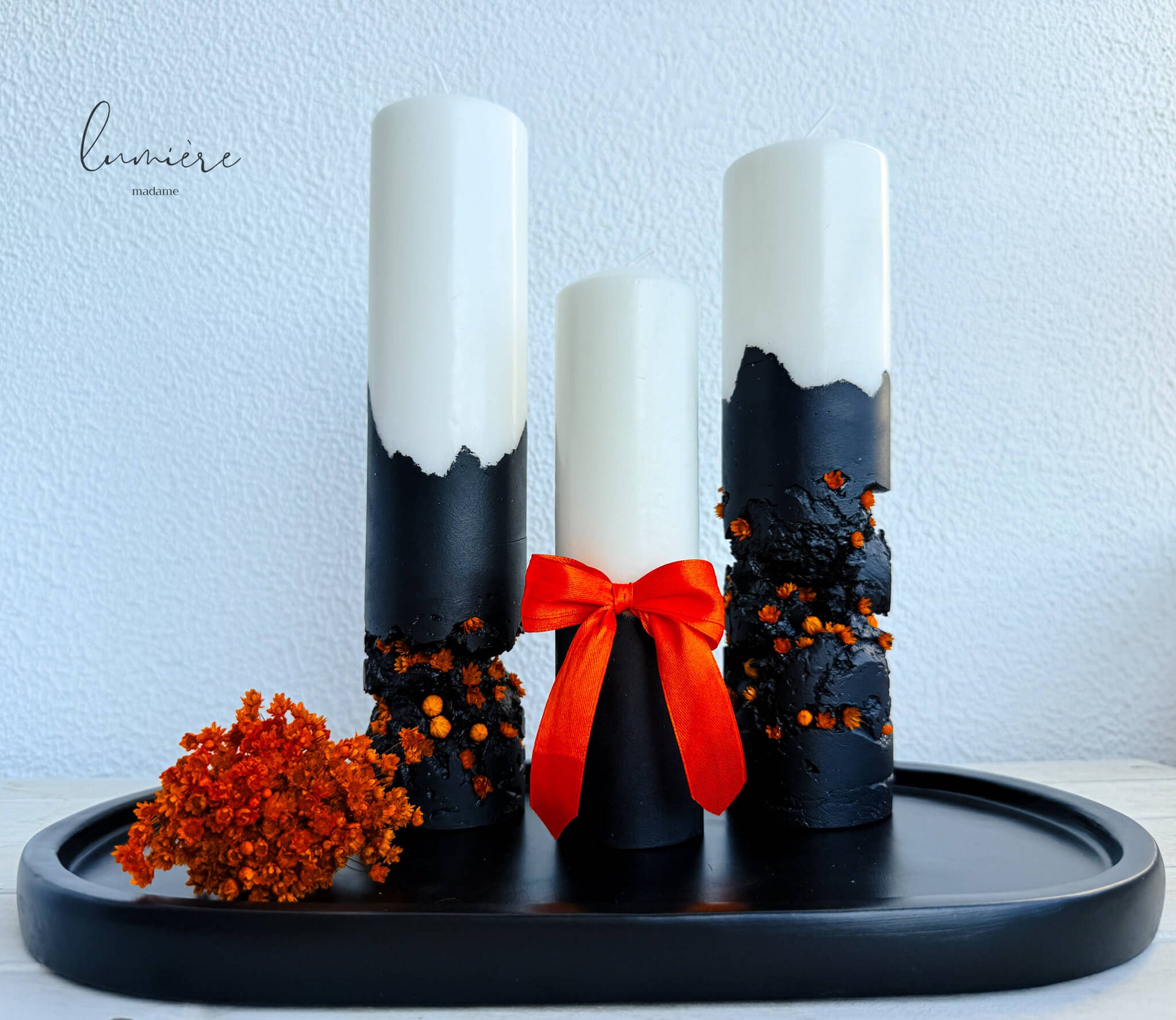 Lumânare Black Ember cu fundiță portocalie decorativă și textură artizanală din ciment.