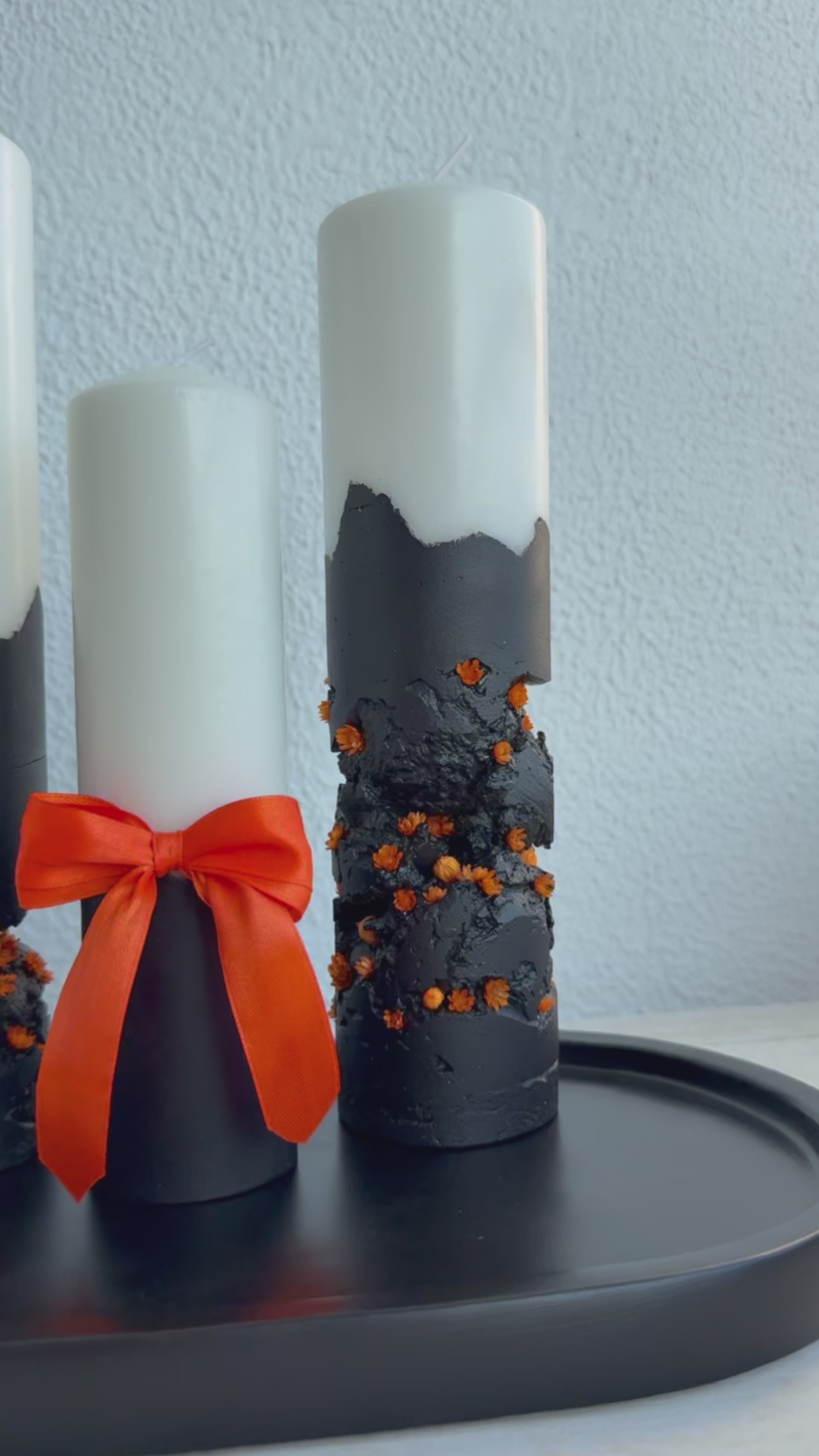 Lumânare Black Ember cu fundiță portocalie decorativă și textură artizanală din ciment.