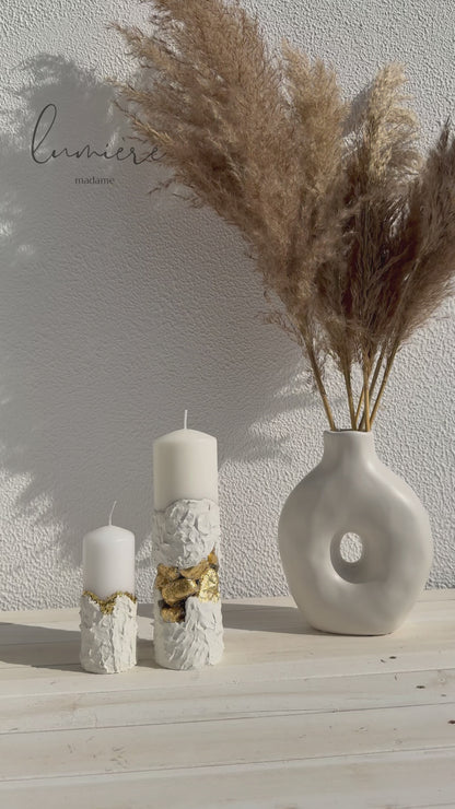 Lumânare albă sculpturală cu pietre aurii decorative, realizată manual din ciment cu design premium.
