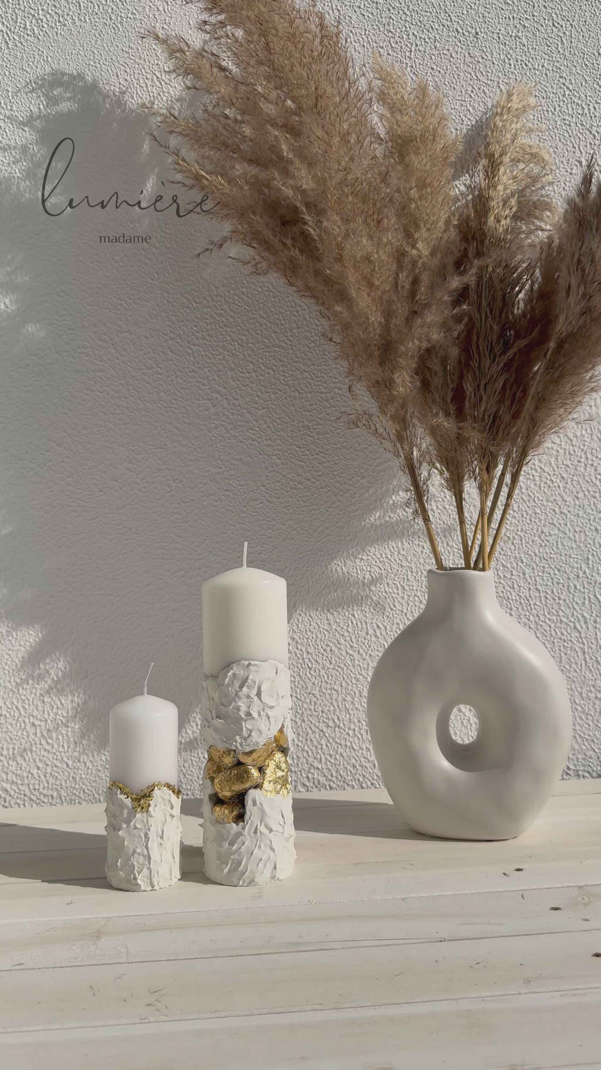 Lumânare albă sculpturală cu pietre aurii decorative, realizată manual din ciment cu design premium.