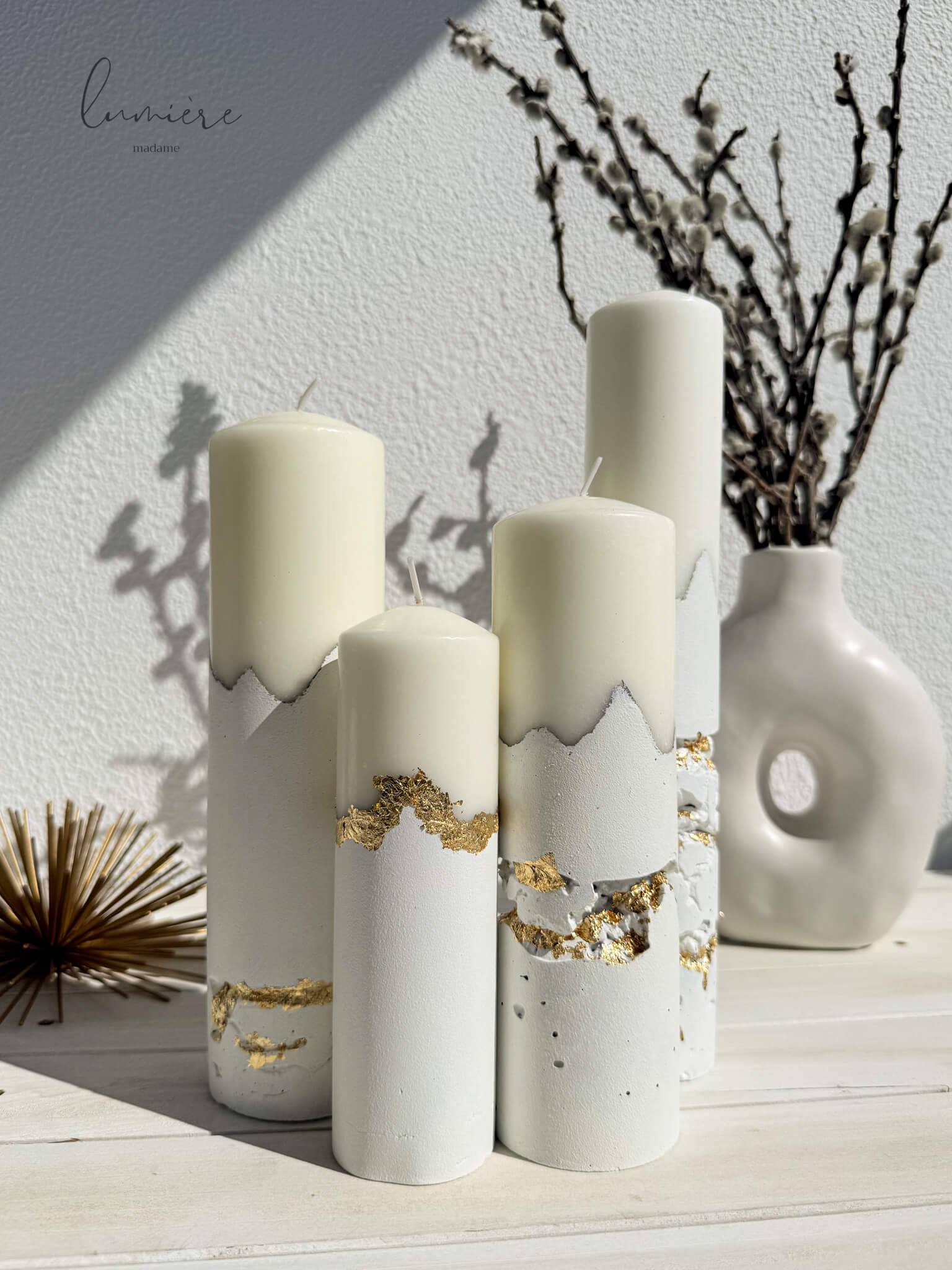 Set de lumânări sculpturale albe cu accente aurii aplicate manual, realizate din ciment cu design minimalist.